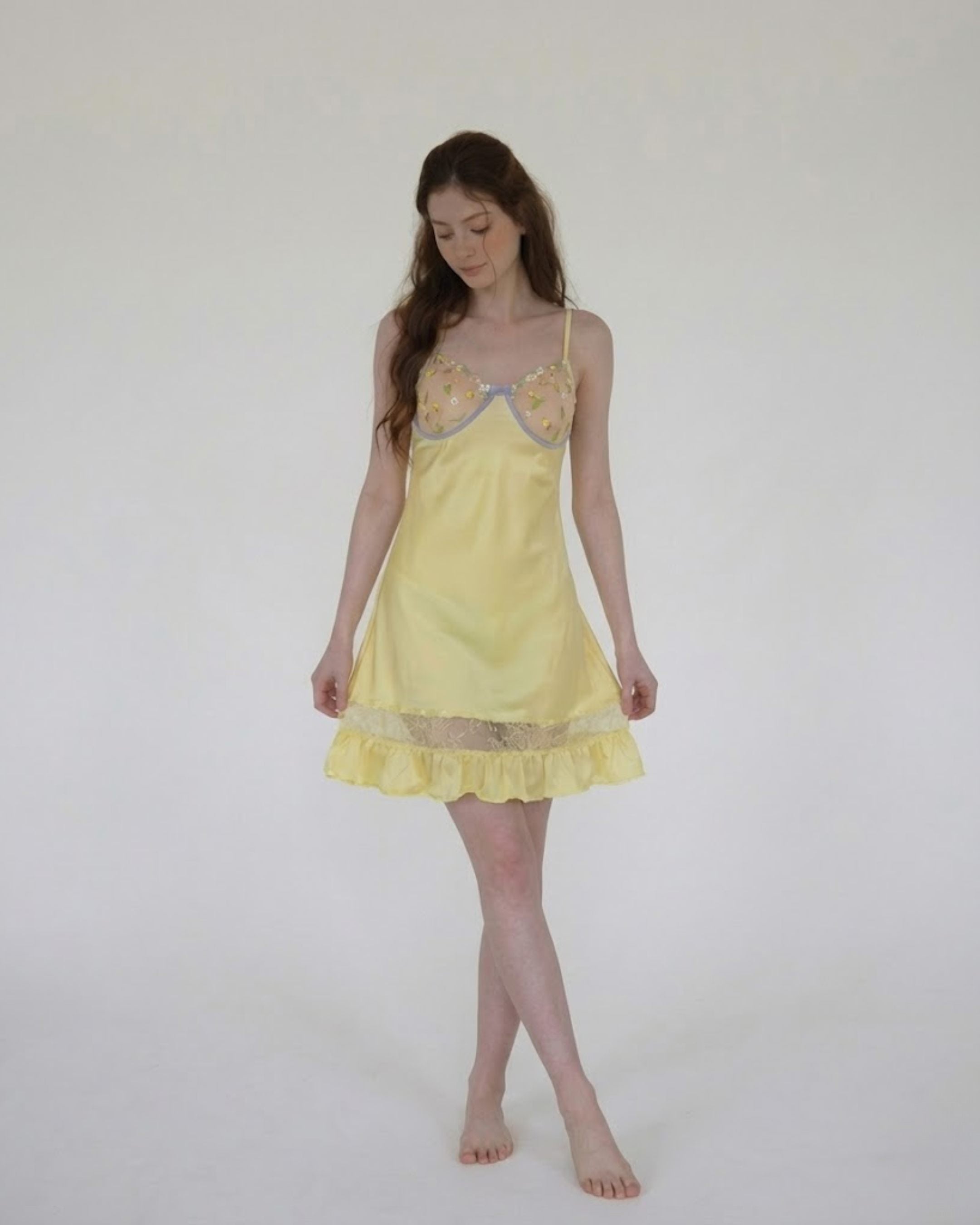 Woman wearing a fairyberry yellow lace nightgown against a white background