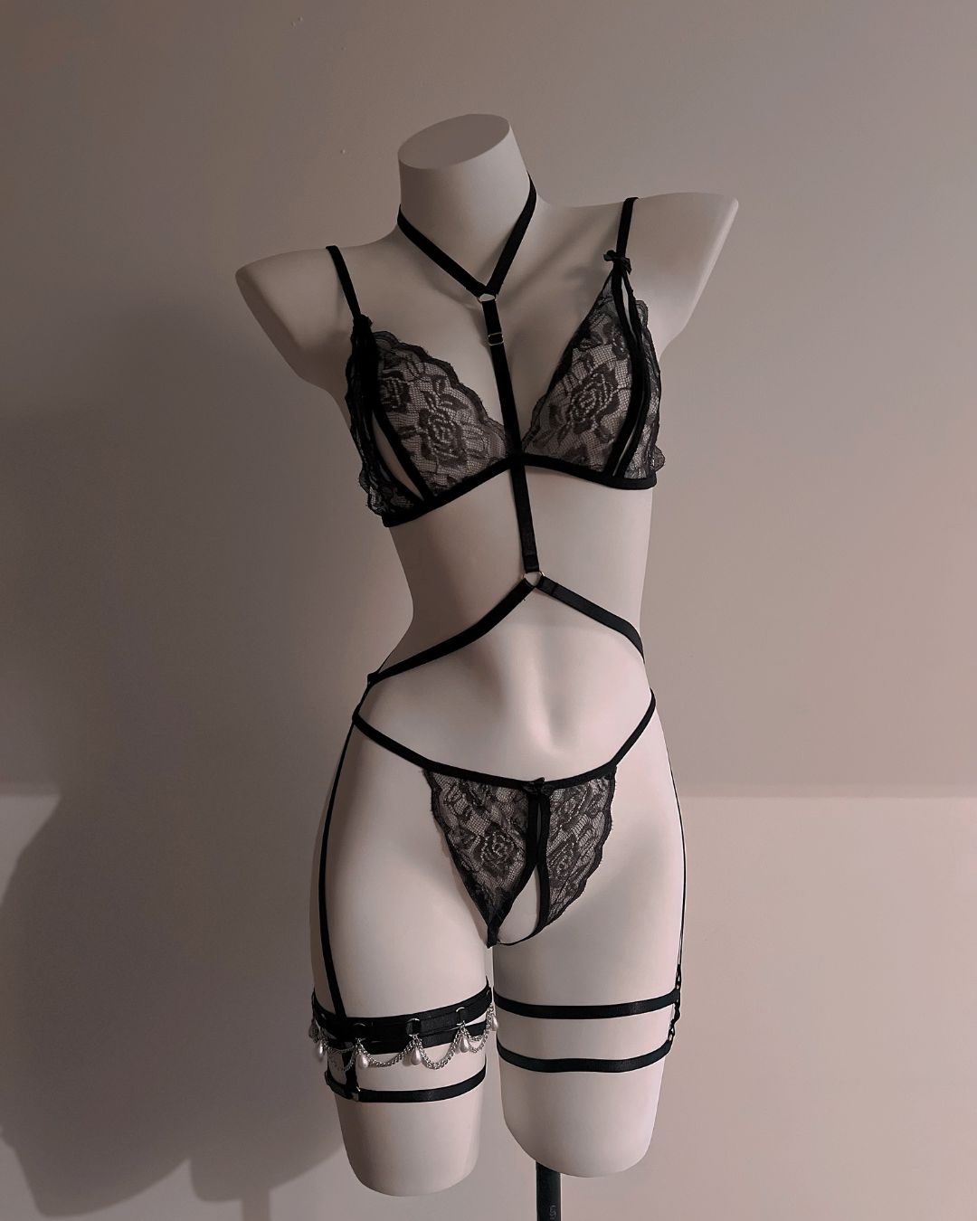 Black lace lingerie set on a mannequin against a neutral background