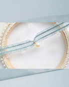 Soft mint green ruffled choker with teardrop pearl charm styled in dreamy pastel setting – delicate neckwear