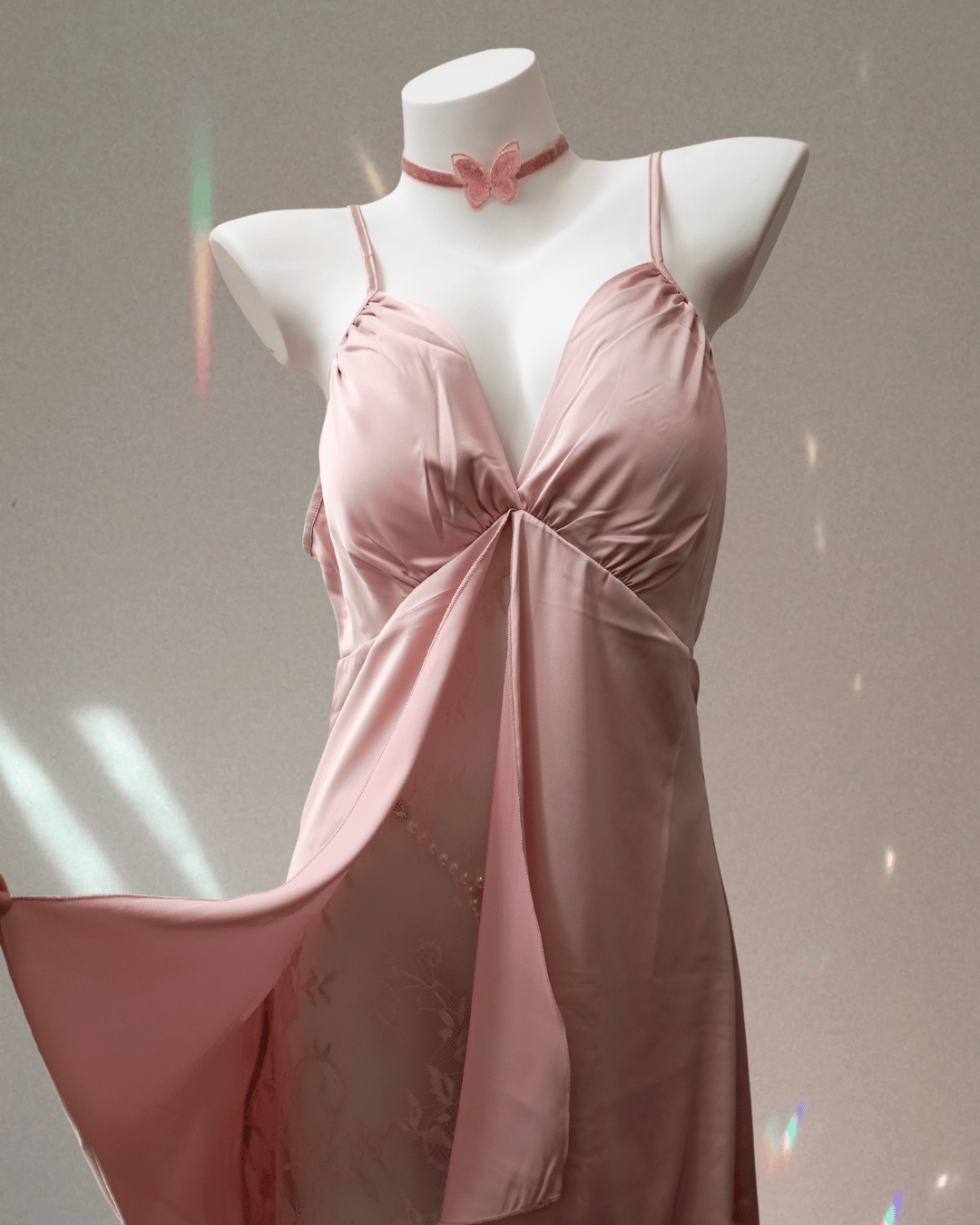 Pink satin nightgown on a mannequin against a neutral background