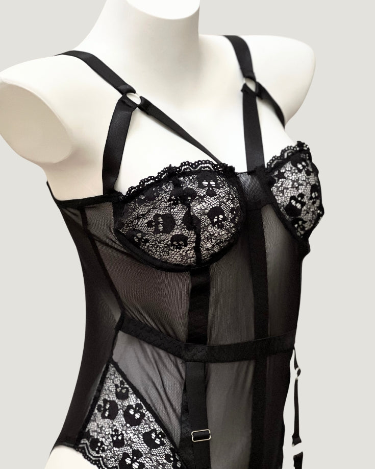 Detailed close-up of Ravenbite’s skull-embroidered lace cups with scalloped edges and harness-style straps.