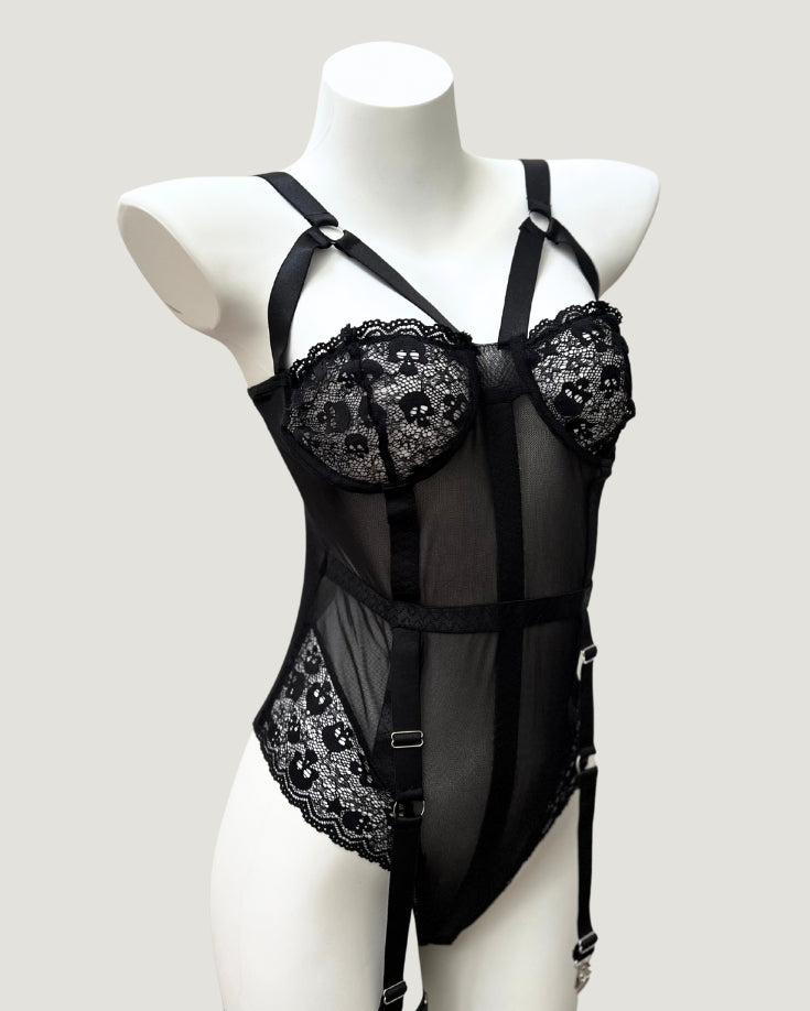 Mid-body view showing sheer black mesh panels, vertical shaping seams, and waist belt detail on the Ravenbite Bodysuit.