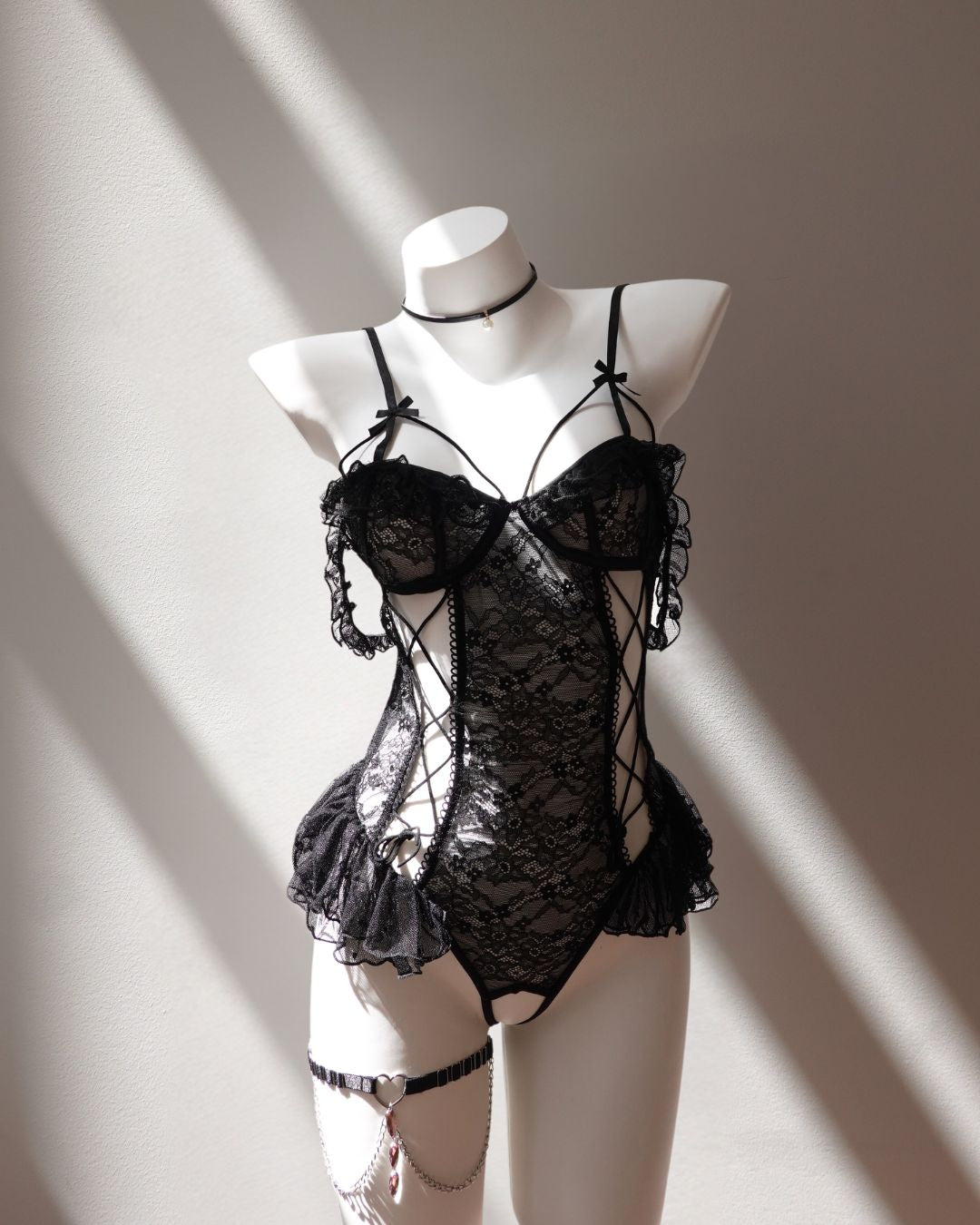 Black lace lingerie set on a mannequin against a neutral background