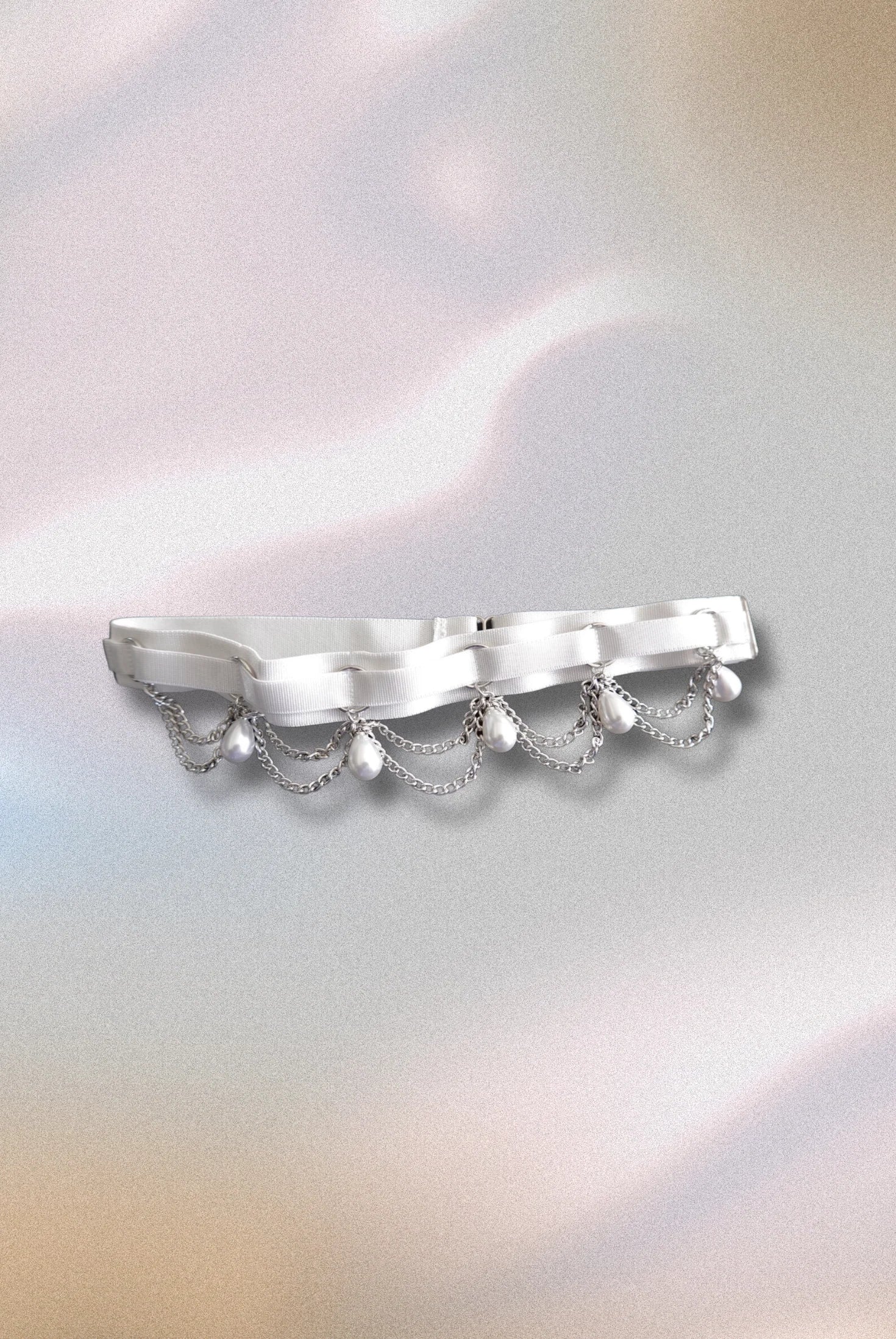 Close-up of white elastic garter with silver O-ring accents – minimal and adjustable legwear detail
