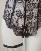 Black lace garment on a mannequin with a neutral background