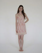 Woman wearing a floral nightgown against a plain background