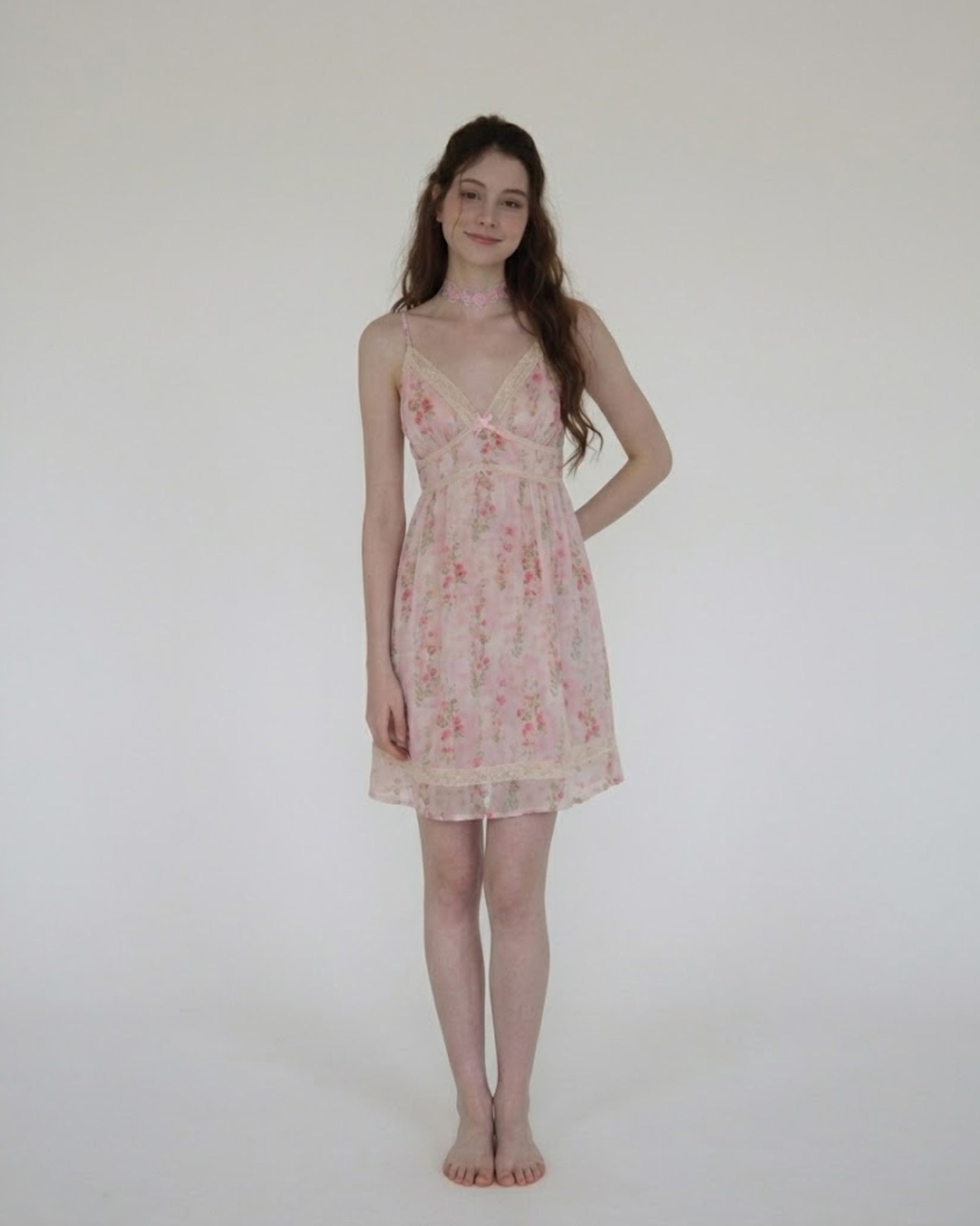 Woman wearing a floral nightgown against a plain background