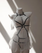 White lace dress with black bondage lingerie accents on a mannequin against a neutral background