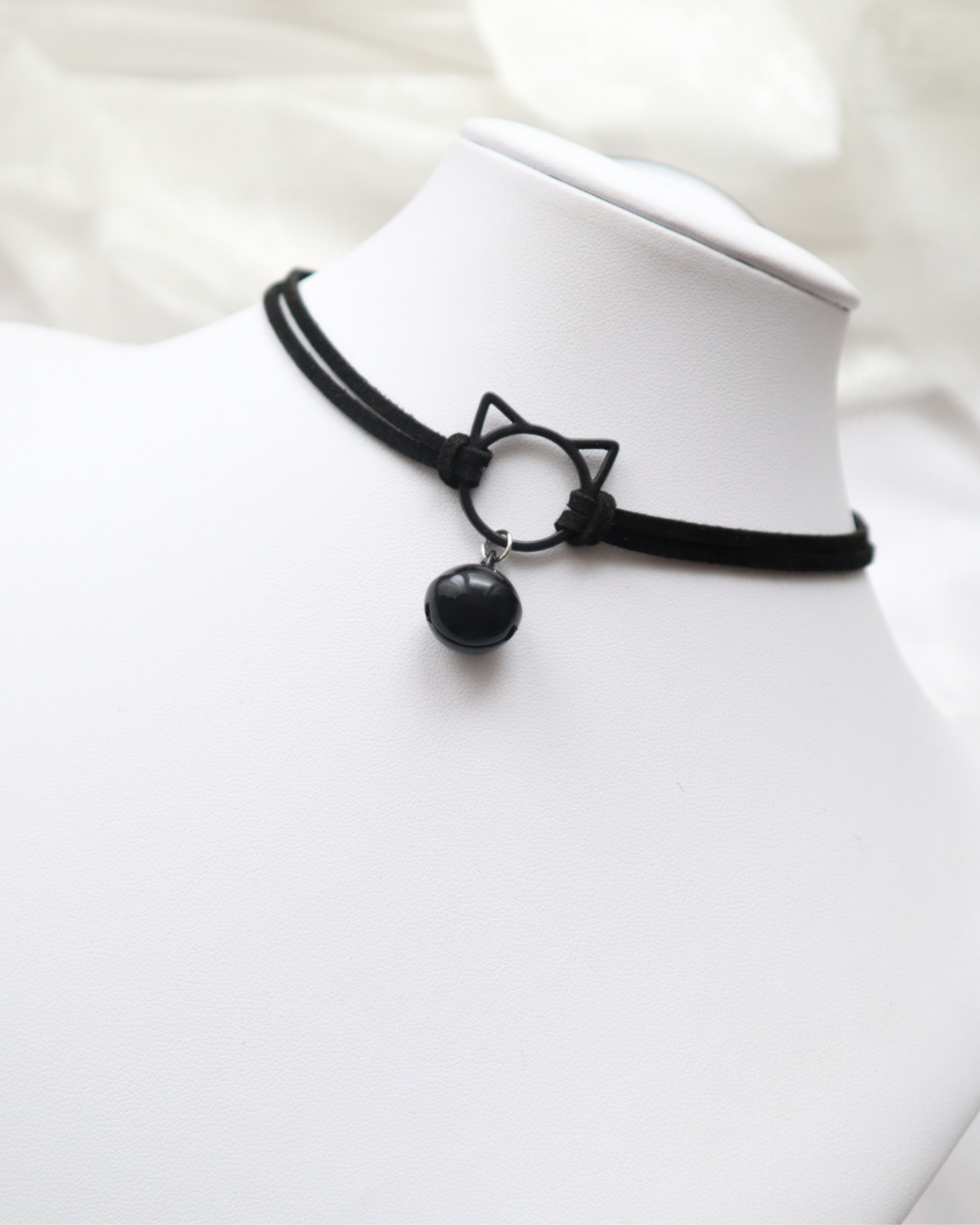 Black choker necklace with cat-shaped pendant on a white background