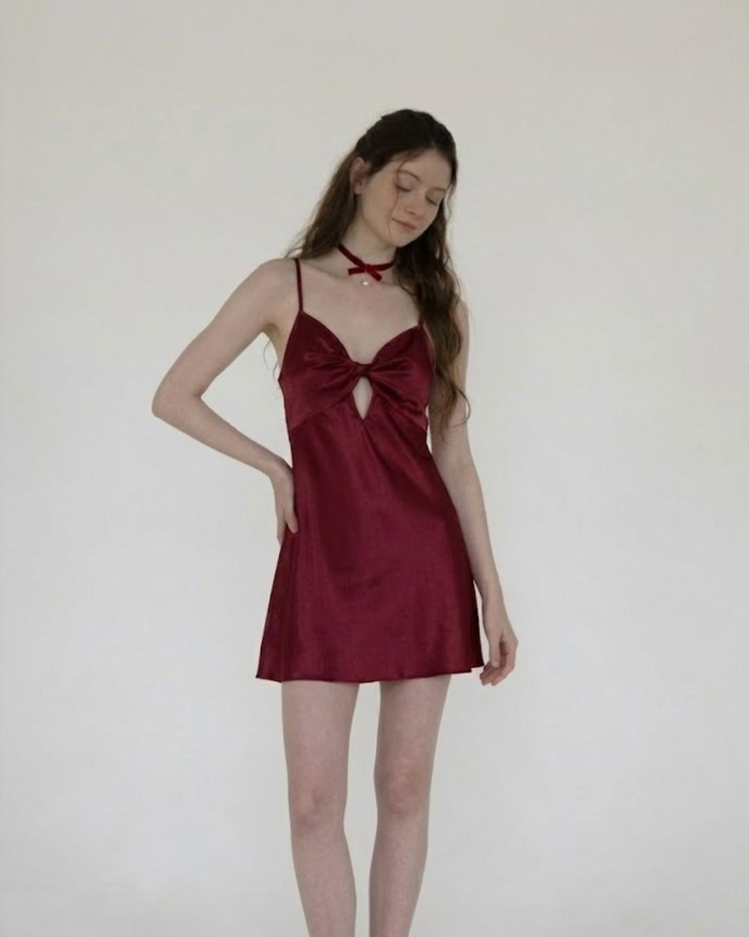 Woman wearing a fairyberry burgundy red satin nightgown against a plain background