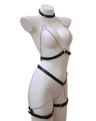 Black leather harness with chain details on a mannequin against a white background