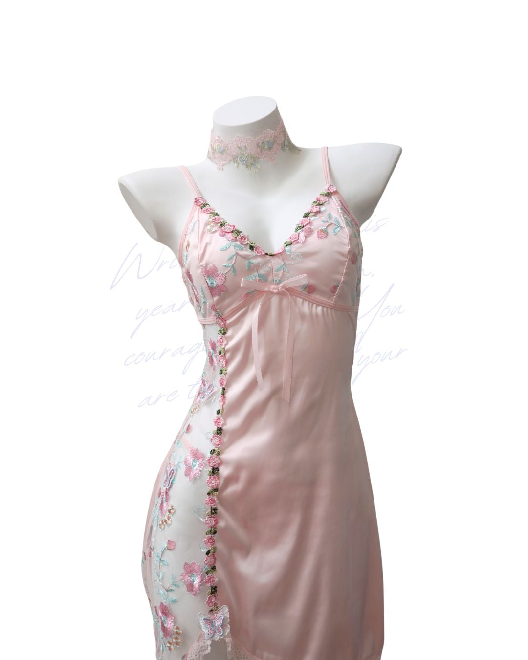 Pink satin nightgown with floral embroidery on a mannequin against a white background