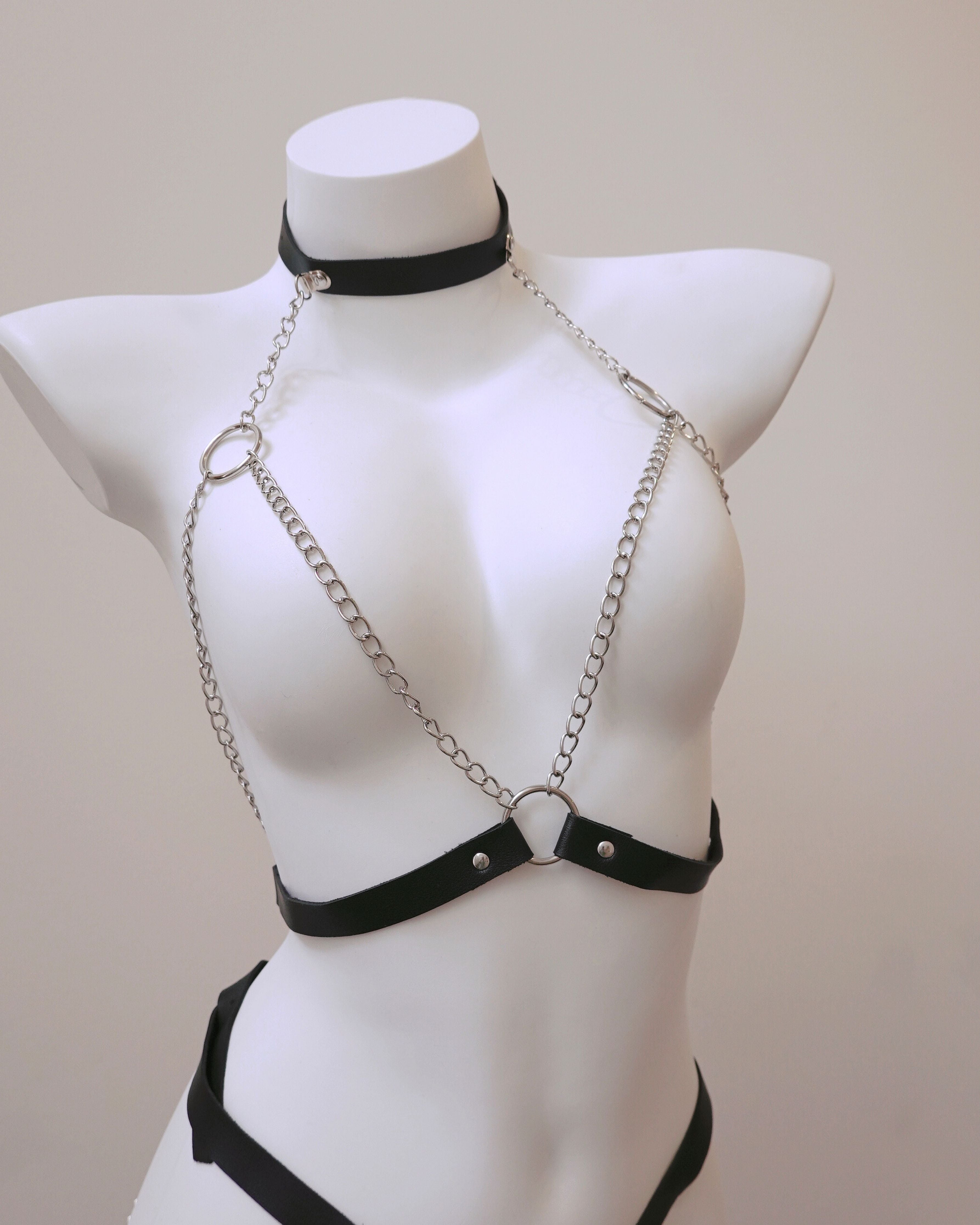 Black chain harness on a mannequin against a beige background