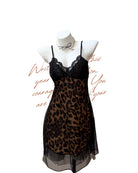 A black and brown leopard print babydoll chemise dress with a black lace bodice and thin spaghetti straps, displayed on a white mannequin torso against a white background with decorative red cursive text.
