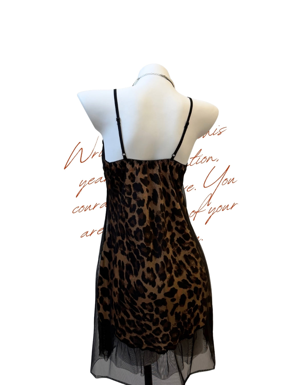 A leopard print slip dress with black spaghetti straps and a sheer black mesh hem, displayed on a white mannequin torso against a white background with red cursive text.