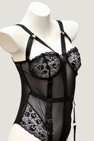 Detailed close-up of Ravenbite’s skull-embroidered lace cups with scalloped edges and harness-style straps.