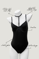 Black Moonlock Bodysuit featuring sleek matte fabric and silver ring detail on strappy neckline. Minimalist lingerie design.